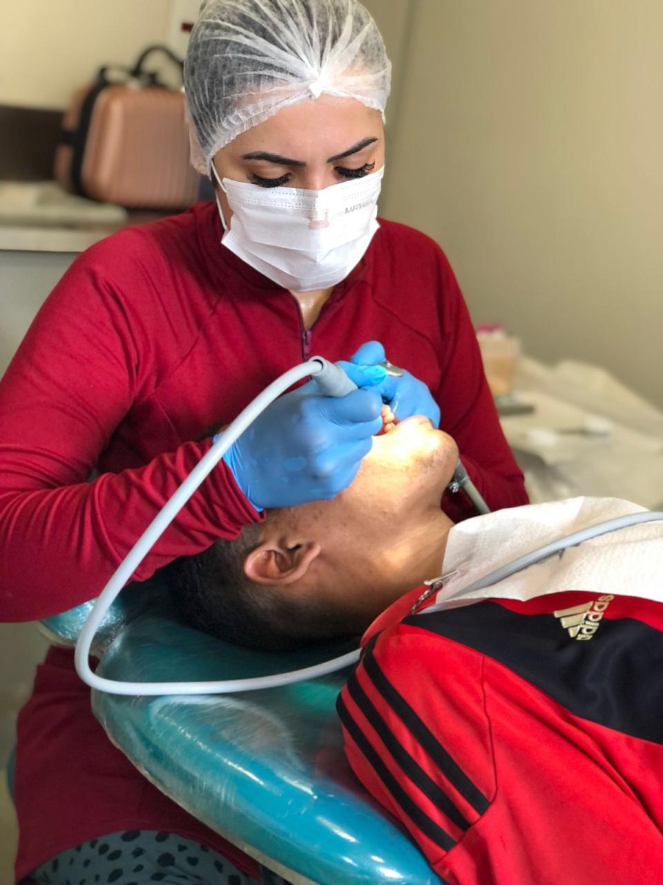 Profissional realizando atendimento odontológico